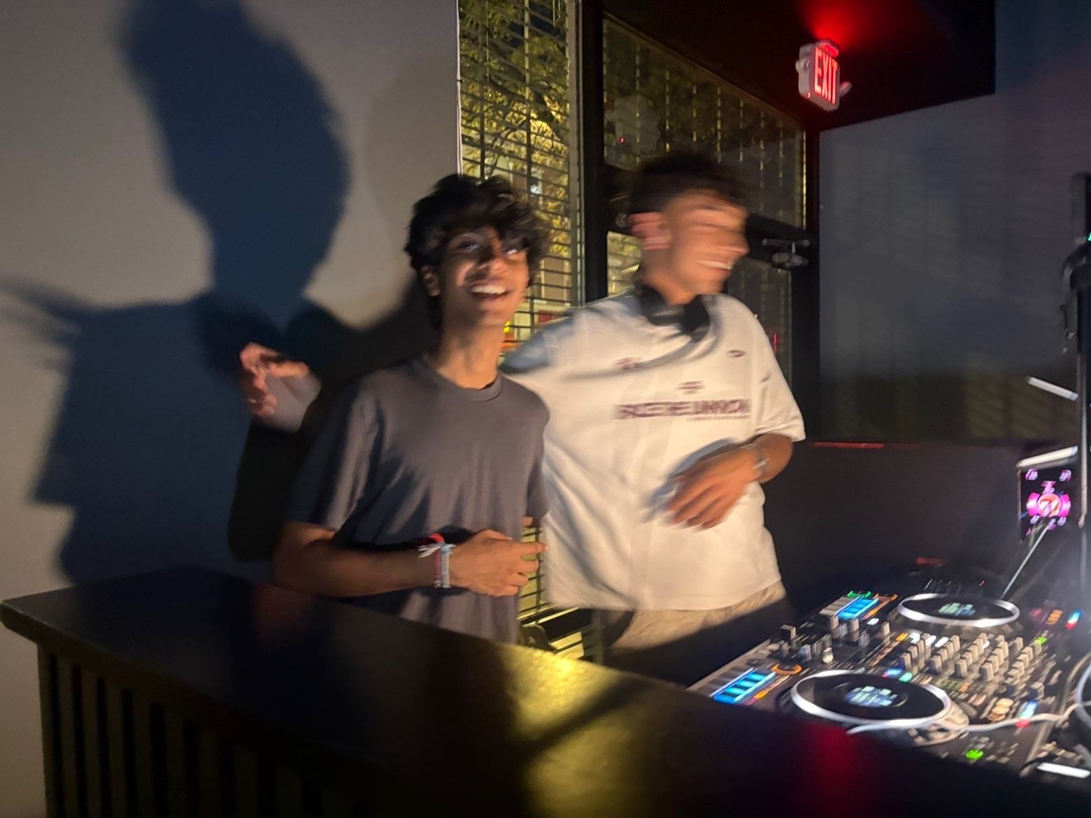 Two DJs laughing in the booth