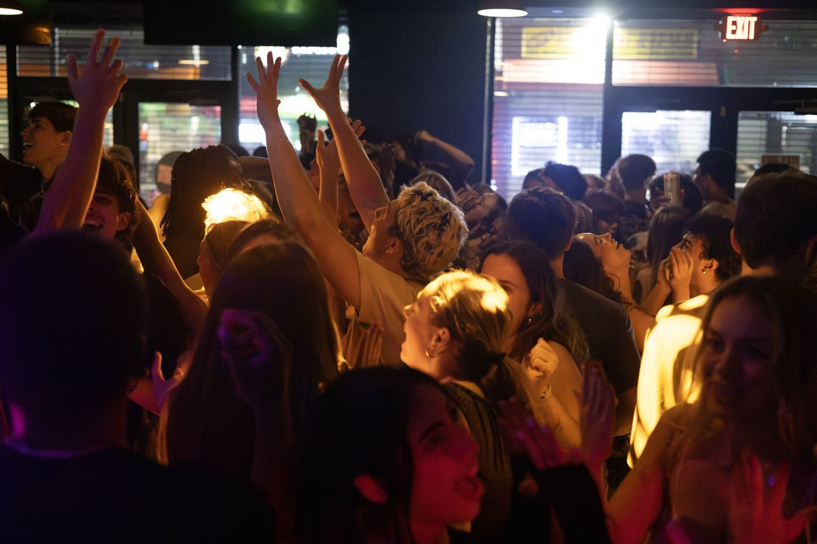 Crowd with hands in the air under warm stage light